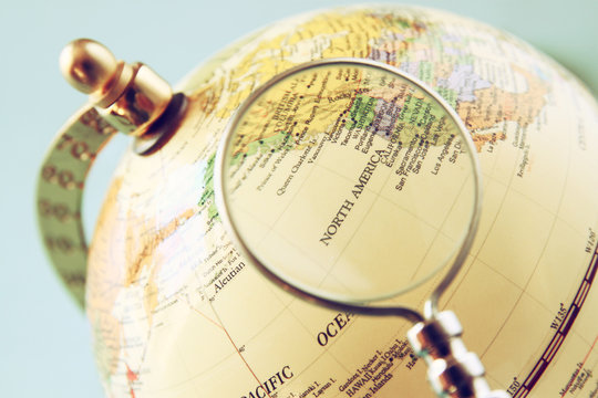 close up of old vintage globe and magnifying glass