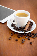 coffee and tablets on a wooden table in coffee shop