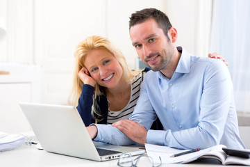Young attractive couple using laptop at home