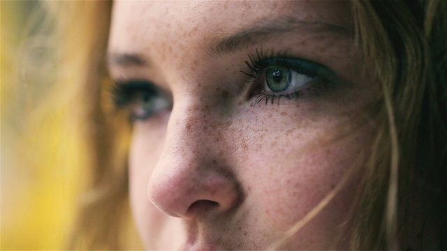View of beautiful girl with blue eyes and freckles, closeup
