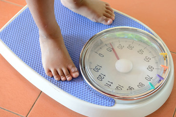 view of scales on a floor and kids feet