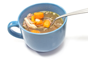 Beef and vegetable broth in  bowl with spoon on white