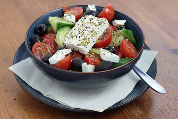 Greek salad in a deep blue bowl.