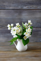 White flowers in a vase on  wooden surface