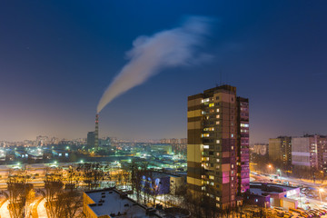 Fototapeta premium The smoke from industrial pipe in the city at night
