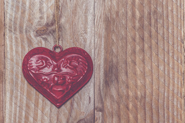 Coeur rouge en métal sur du bois
