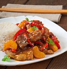 Meat in a spicy sauce, sweet pepper and tangerines with a garnis