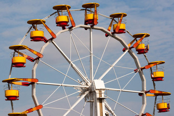 Ferris wheel with bright colored cabins in amusement park.
