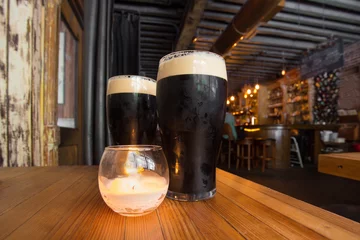 Foto auf Leinwand Dark beer and candle in pub setting © littleny