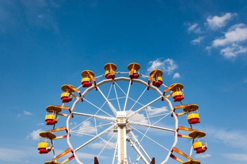 Ferris wheel with bright colored cabins in amusement park.