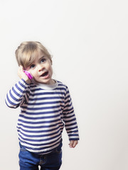 Cute little girl talking with a pink phone isolated