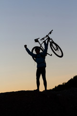 Silhouette of a cyclist celebrating making the top