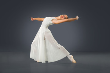 Fototapeta na wymiar Beautiful female ballet dancer on a grey background.