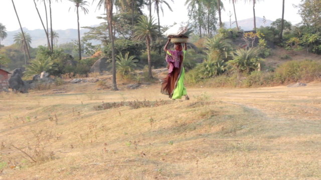 Indian rural woman carries heavy things on her head
