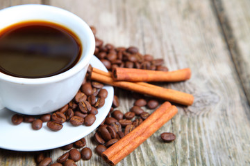 Cup of coffee, beans and cinnamon sticks