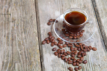 Transparent cup of coffee and coffee beans with the bank