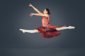 Beautiful female ballet dancer on a grey background.