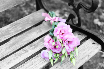 Obraz premium Beautiful bouquet of eustoma flowers on wooden bench in park