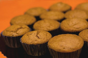 Pile of muffins, selective focus and orange background.