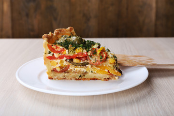 Piece of Vegetable pie with broccoli, peas, tomatoes and cheese