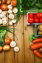 Different vegetables in boxes on wooden background top view