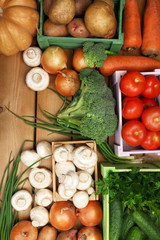 Different vegetables in boxes on wooden background top view