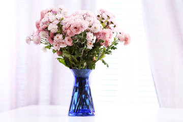 Beautiful flowers in vase with light from window