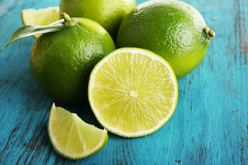 Fresh juicy limes on wooden background
