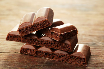 Tasty porous chocolate on wooden table