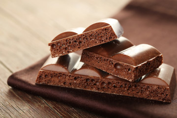 Tasty porous chocolate on wooden table