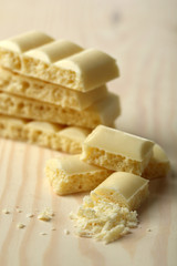 Tasty white porous chocolate on wooden table, close up