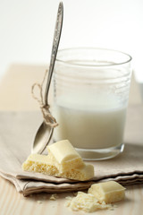 Tasty white porous chocolate and glass of milk,