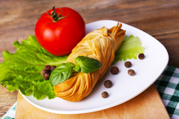 Smoked braided cheese on wooden table