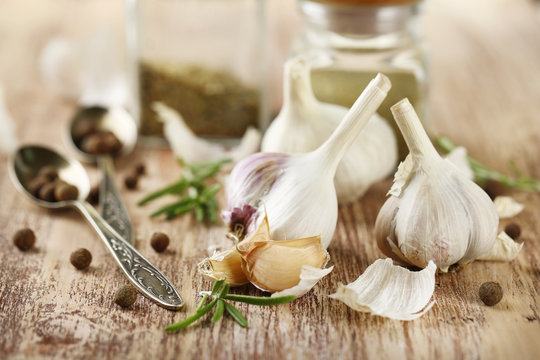 Raw garlic and spices on wooden table