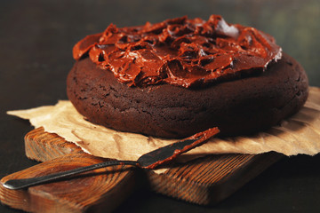 Chocolate cake with chocolate cream on wooden table close-up