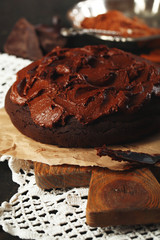 Chocolate cake with chocolate cream on wooden table close-up