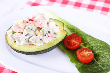 Tasty salad in avocado on plate close-up