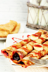 Plate of delicious pancakes with berry jam on wooden background
