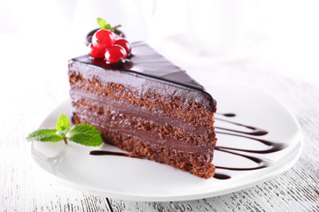 Delicious chocolate cake on plate on table on light background