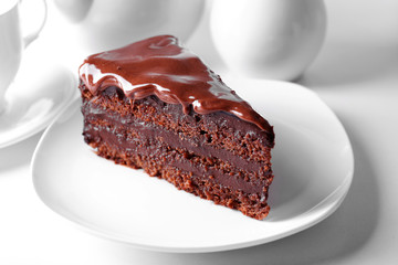 Delicious chocolate cake on plate on table on light background