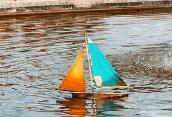 Small toy boat sailing on a lake