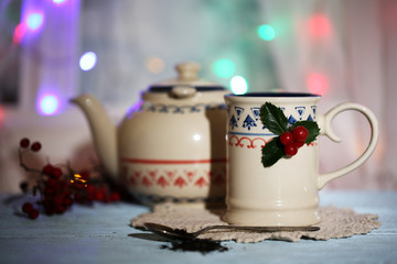 Christmas composition with cup and teapot of hot drink,