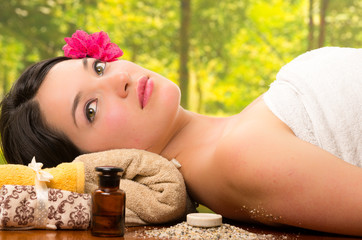 Obraz na płótnie Canvas beautiful brunette woman lying down in outdoor spa