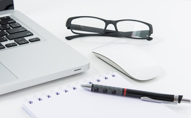 Blank business laptop, mouse, pen, glasses and note