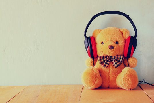 teddy bear with headphones over wooden table