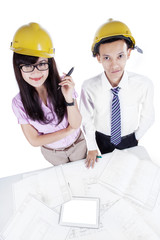 Two architects with blueprint looking at camera