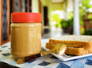 Jar of peanut butter and toasts on summer terrace