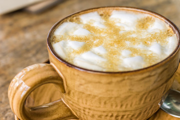 Orange coffee cup on wooden table background