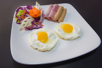 Plate of breakfast with fried eggs, bacon and toasts isolated ba