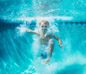 Young Boy Diving Underwater in Swimming Pool